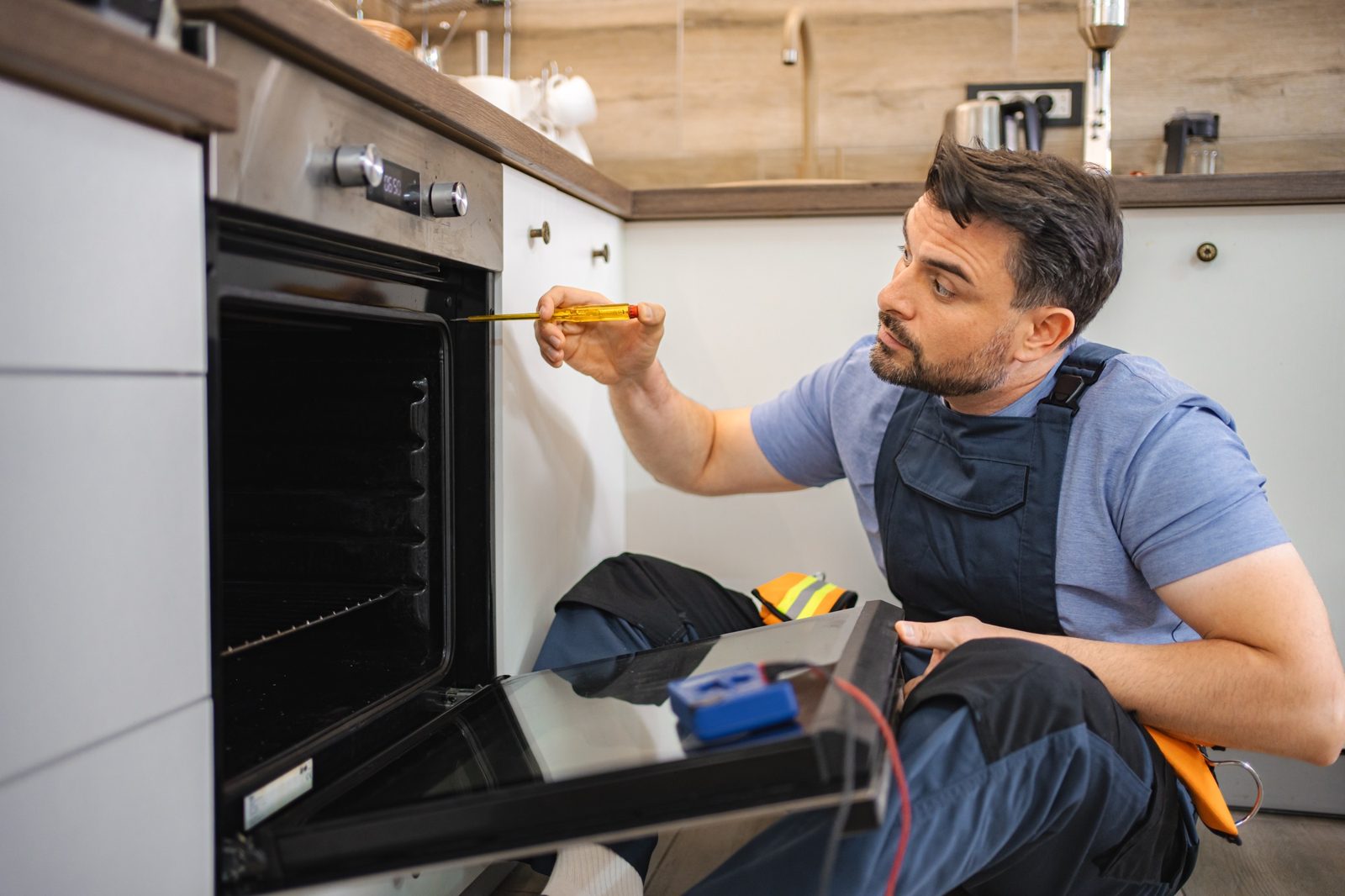 Technician testing the heating element of an electric oven